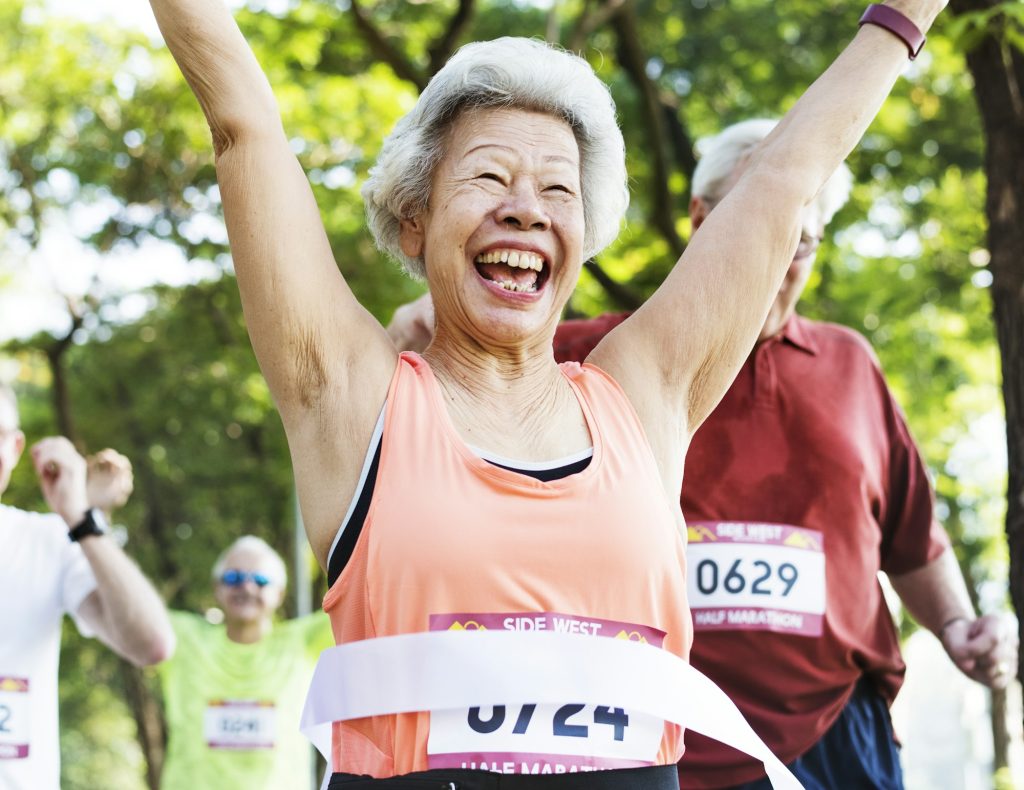 Elderly asian woman reaching the finish line