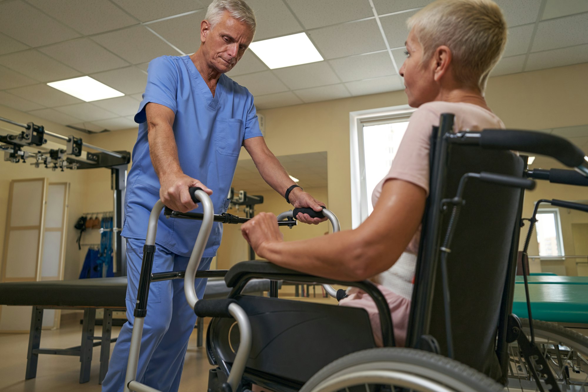 Patient woman uses with walking frame in rehab center